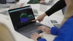 a photo of a person pointing at a laptop displaying a Visible Geology geological model