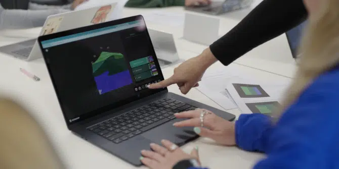 a photo of a person pointing at a laptop displaying a Visible Geology geological model