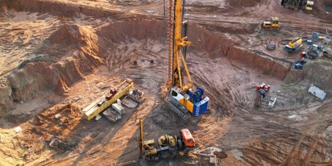 A photograph of an exploration and mining environment that has a core drill and various vehicles and pieces of machinery