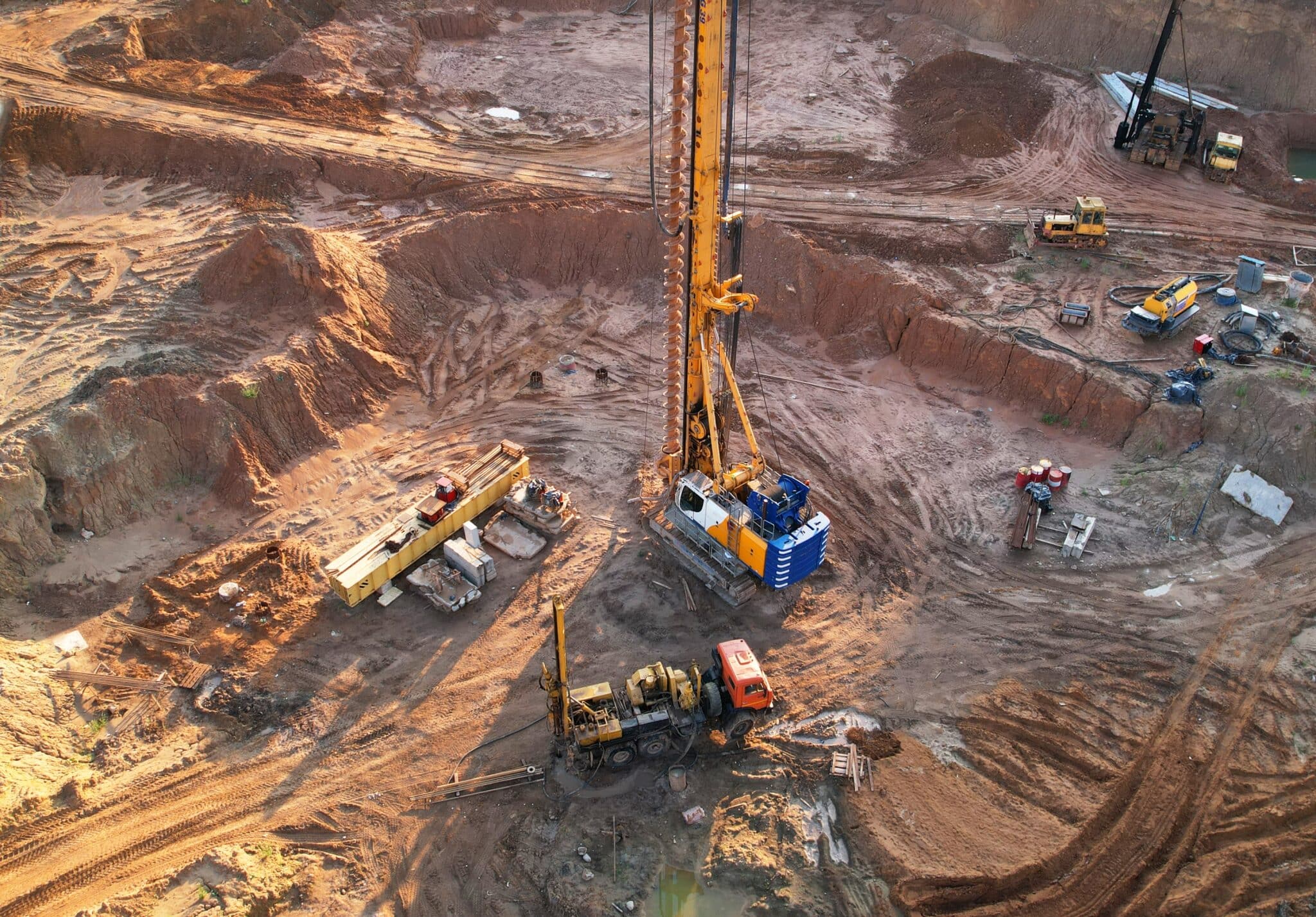 A photograph of an exploration and mining environment that has a core drill and various vehicles and pieces of machinery