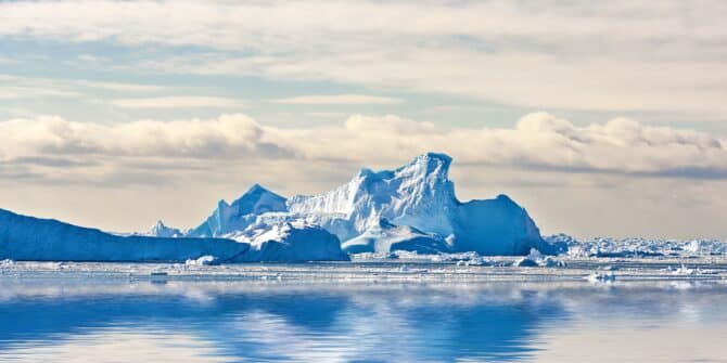 Antarctica, climate change and water with ice in ocean for cold ecosystem of environment in winter season. Earth, iceberg and sky with frost on sea for conservation or global warming in mother nature